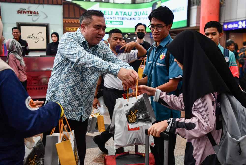 Anthony menyampaikan pek cenderahati kepada penumpang KTMB sempena sambutan Hari Raya Aidilfitri di KL Sentral pada Jumaat. Foto Bernama