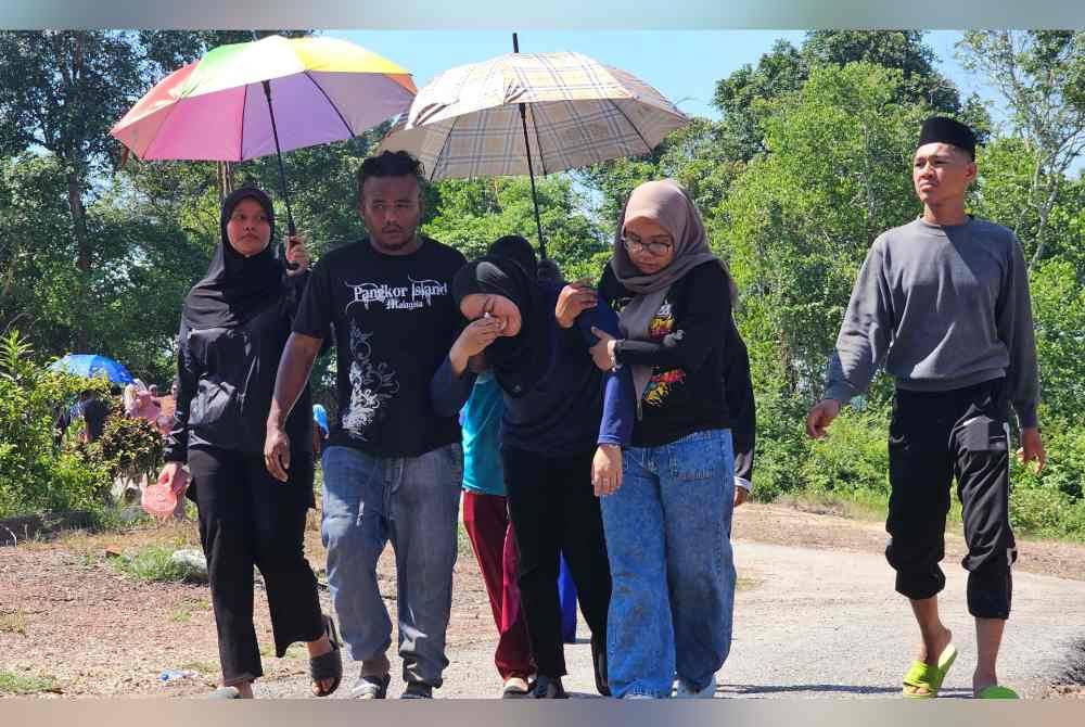 Norzalifa dipapah oleh suami Norazlan Tajuddin, 37, dan anak sulungnya, Puteri Nurdiana, 19, selepas selesai pengebumian dua anaknya diTanah Wakaf Perkuburan Islam Kampung Perik, Enggor.