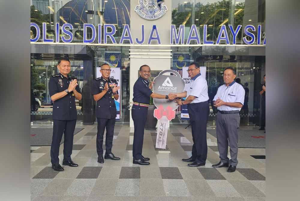 Sazally (dua dari kanan) menyerahkan replika kunci kenderaan peronda kepada Razarudin (tengah) di Ibu Pejabat Polis Bukit Aman pada Jumaat.