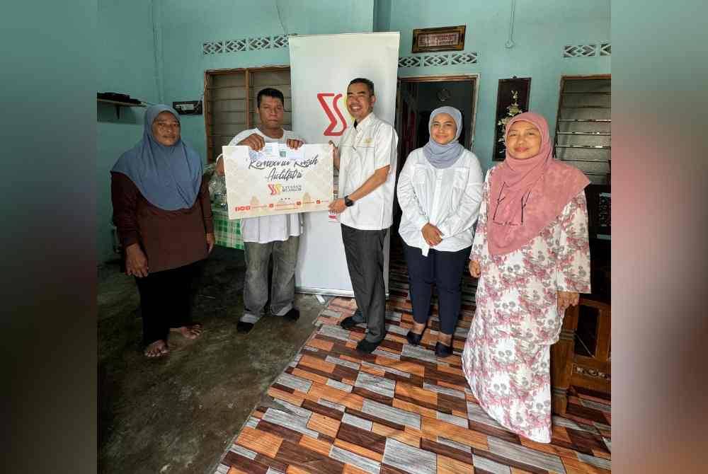 Zaini (tiga dari kanan) menyampaikan sumbangan kepada salah seorang penerima YS.
