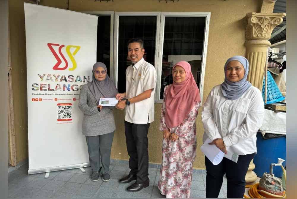 Zaini (dua kiri) menyampaikan sumbangan kepada salah seorang penerima YS.