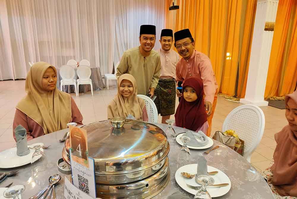 Saiful Zaini (kanan) menyantuni anak-anak yatim dari Rumah Anak Yatim Permata Al Insyirah yang turut diraikan pada majlis berbuka puasa bersama media di sini pada Jumaat.
