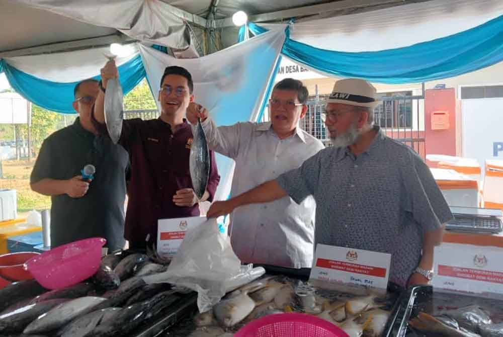 (Dari kanan) Syed Abu Hussin Hafiz, Johari dan Dr Mohammed Taufiq semasa meninjau Program Jualan Termurah Madani di Bandar Perdana, Sungai Petani pada Sabtu.