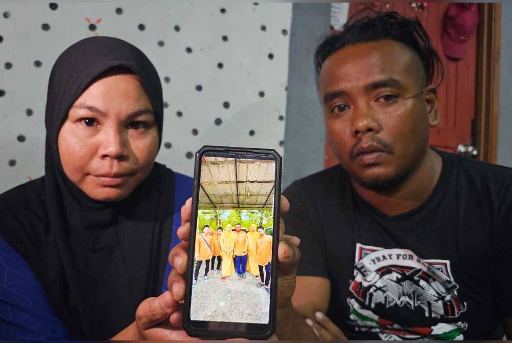 Norzalifa dan suaminya, Norazlan menunjukkan gambar kenangan mereka sekeluarga pada Hari Raya Aidilfitri tahun lalu.