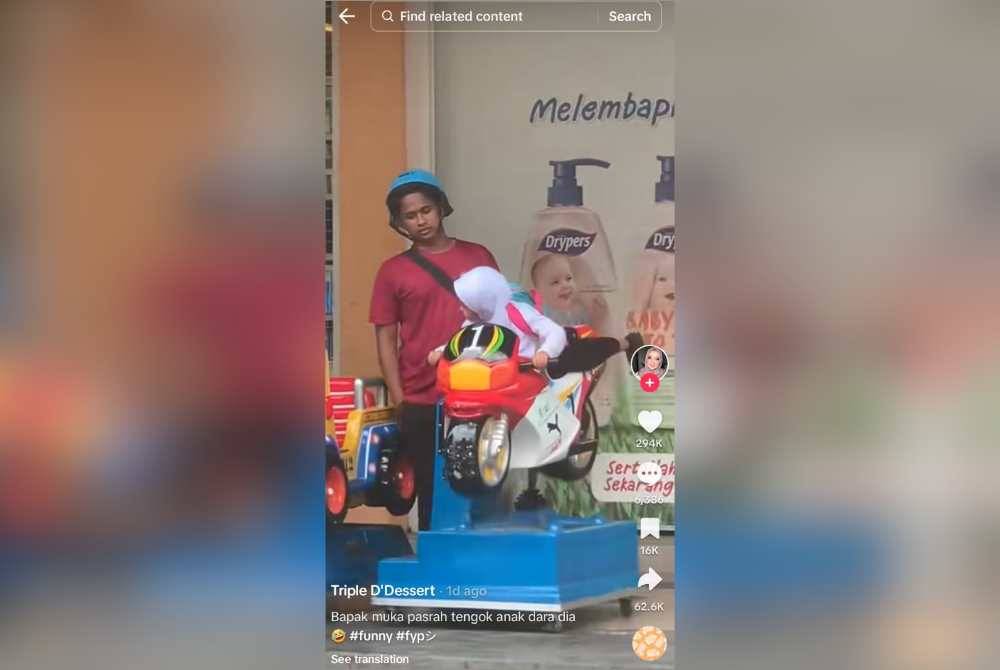 Tangkap layar rakaman video tular memaparkan seorang bapa pasrah melayan anak bermain motosikal permainan di sebuah pasar raya.