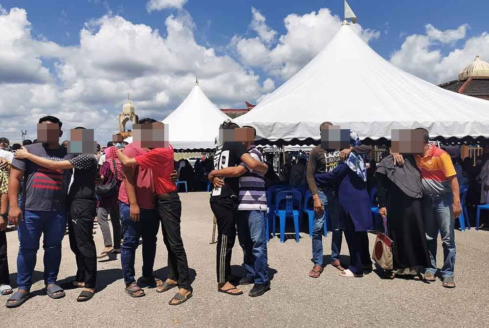 Banduan dibebaskan memeluk keluarga yang sedia menyambut kepulangan mereka.