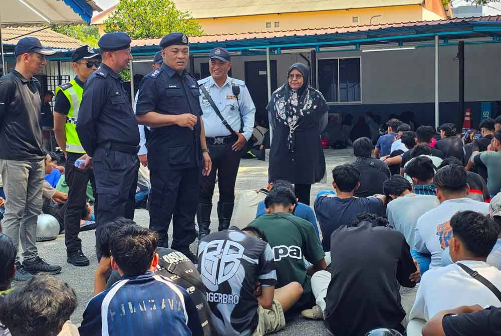 Abang Zainal Abidin (tengah) melakukan pemeriksaan dan proses dokumentasi terhadap individu yang ditahan dalam Op Bersepadu Samseng Jalanan di Ipoh pada Ahad.