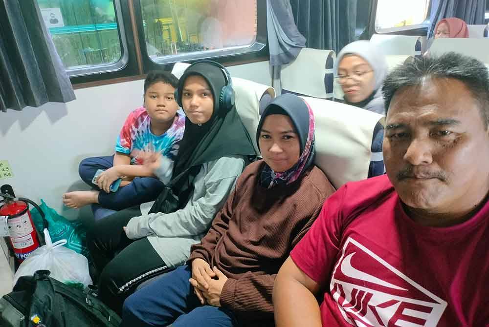 Idah (tengah) bersama suami dan anak-anak pulang menaiki feri untuk beraya di Tanjung Balai, Indonesia.