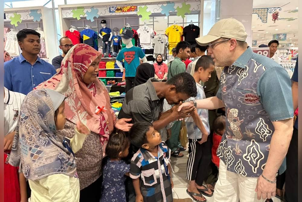 Mohd Ismail (tengah) bersalaman dengan Tengku Muhammad Fakhry (kanan).