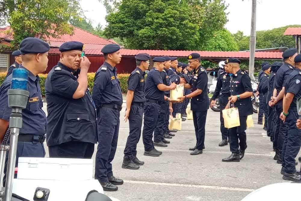 Hanif (dua dari kanan) turut menyampaikan kuih raya kepada pegawai dan anggota terlibat pada majlis sama.