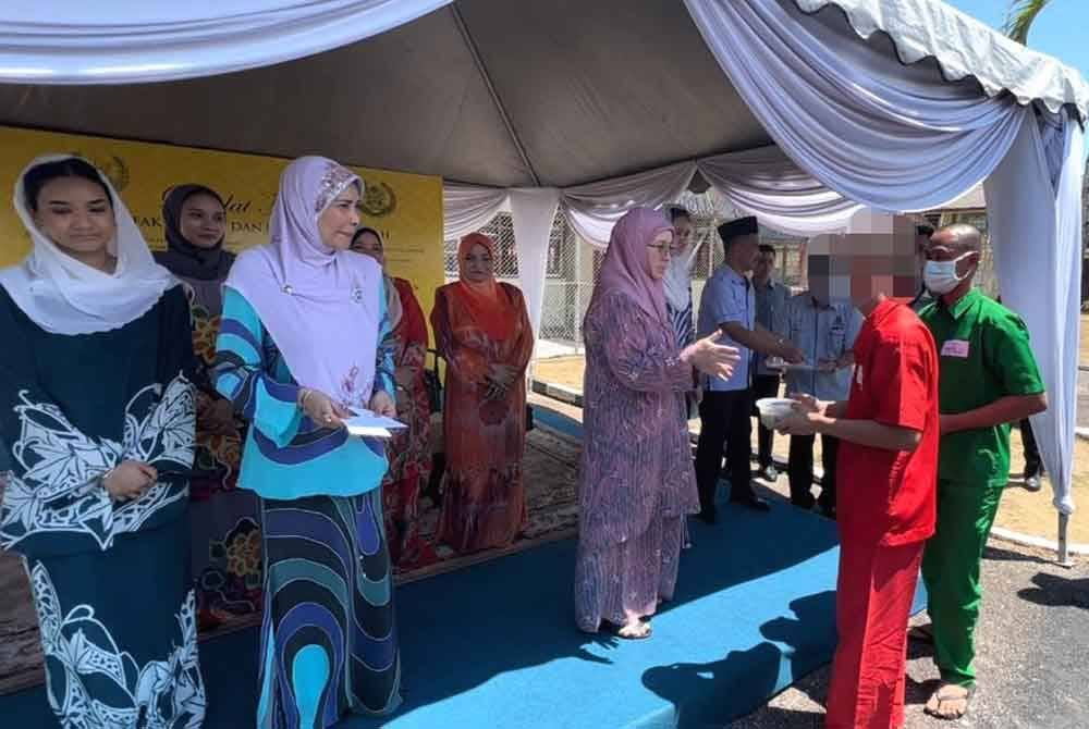 Tunku Azizah mengagihkan bubur lambuk yang siap dimasak kepada penghuni Penjara Marang.