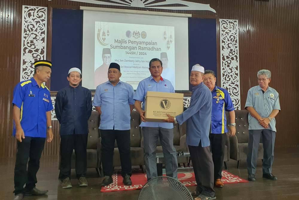 Zambery (empat dari kiri) menyampaikan Sumbangan Aidilfitri anjuran Persatuan Veteran Tidak Berpencen Pulau Pinang di Sekolah Menengah Kebangsaan (SMK) Datuk Haji Abdul Kadir pada Isnin.