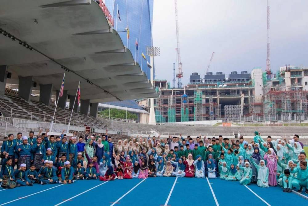 Pengurusan tertinggi PNB bersama penghuni tiga buah rumah kebajikan bergambar kenangan di Stadium Merdeka.