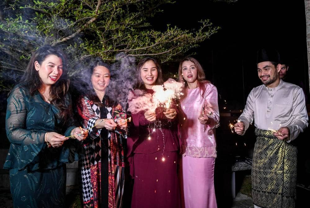 Hannah (dua dari kiri) bermain bunga api bersama atlet semasa majlis berbuka puasa di Bukit Jalil.