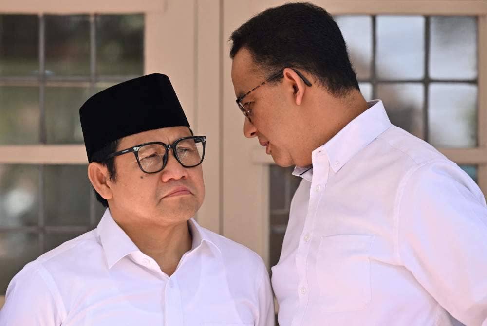 Calon presiden Indonesia, Anies Baswedan (kanan) berunding dengan naib presidennya, Muhaimin Iskandar semasa sidang media di Jakarta selepas suruhanjaya pilihan raya mengumumkan Prabowo Subianto pemenang pilihan raya presiden Februari 2024. Foto AFP