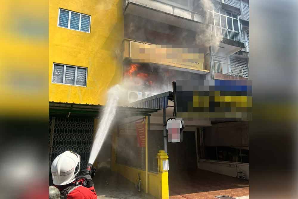 Anggota Bomba dan Penyelamat memadamkan kebakaran di sebuah kedai pakaian di Jalan Kenanga pada Selasa.