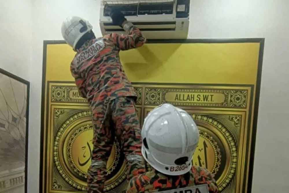 Anggota bomba memeriksa pendingin hawa sebelum menemui sarung kulit ular tedung senduk. Foto bomba