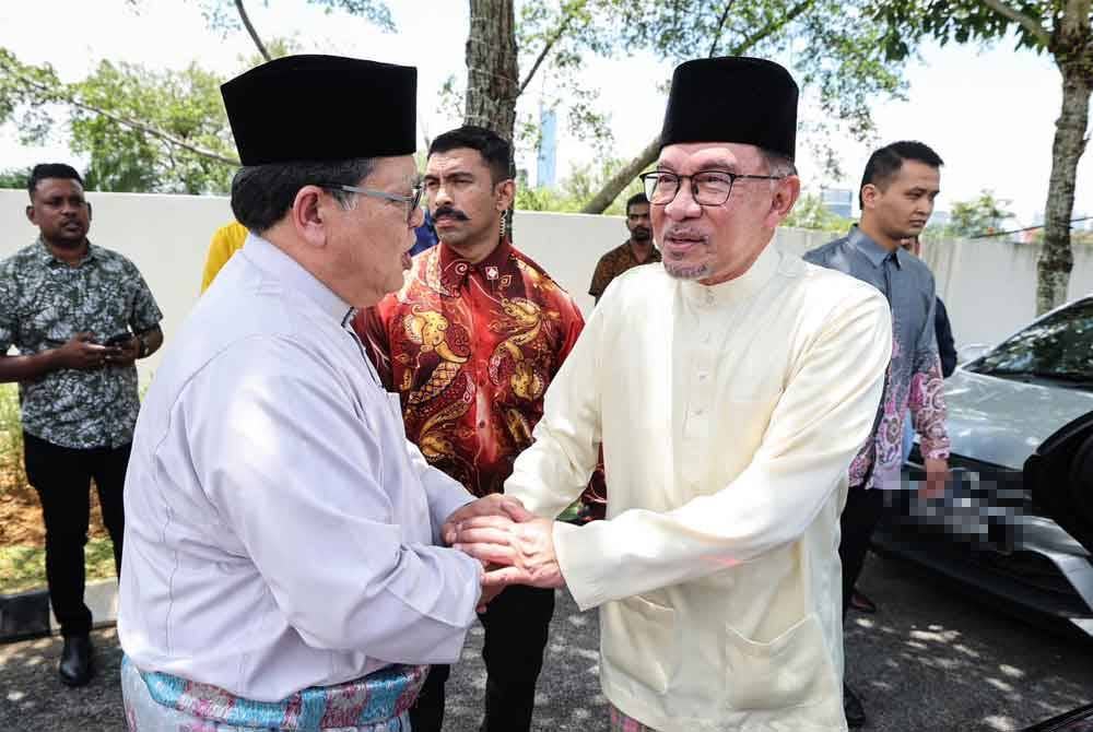 (Kiri) Johari dan Anwar bersalaman ketika majlis rumah terbuka Aidilfitri di Kuala Lumpur pada Khamis.