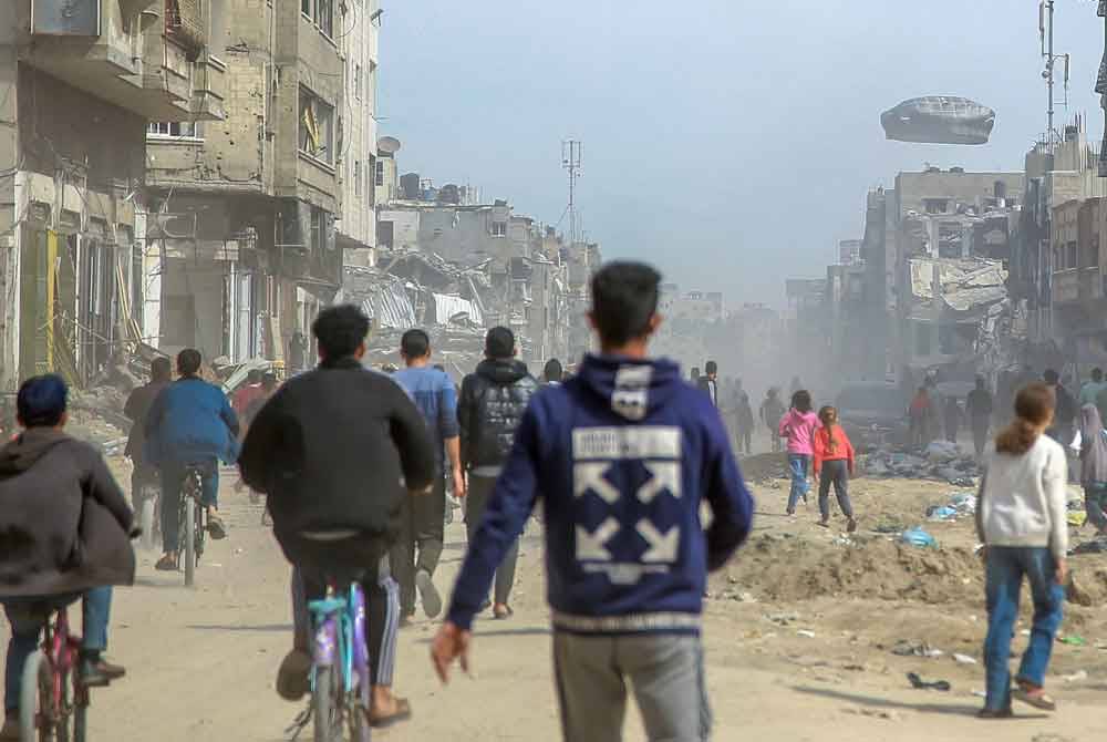 Penduduk Gaza berlari mendapatkan bantuan kemanusiaan yang digugurkan menerusi payung terjun sekitar Gaza City. - AFP