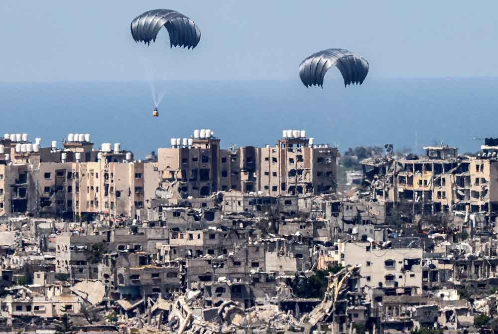 Deretan payung terjun digugurkan ke wilayah di Gaza untuk membantu penduduk yang kini di ambang kebuluran akibat sekatan laluan darat oleh tentera Israel. - AFP
