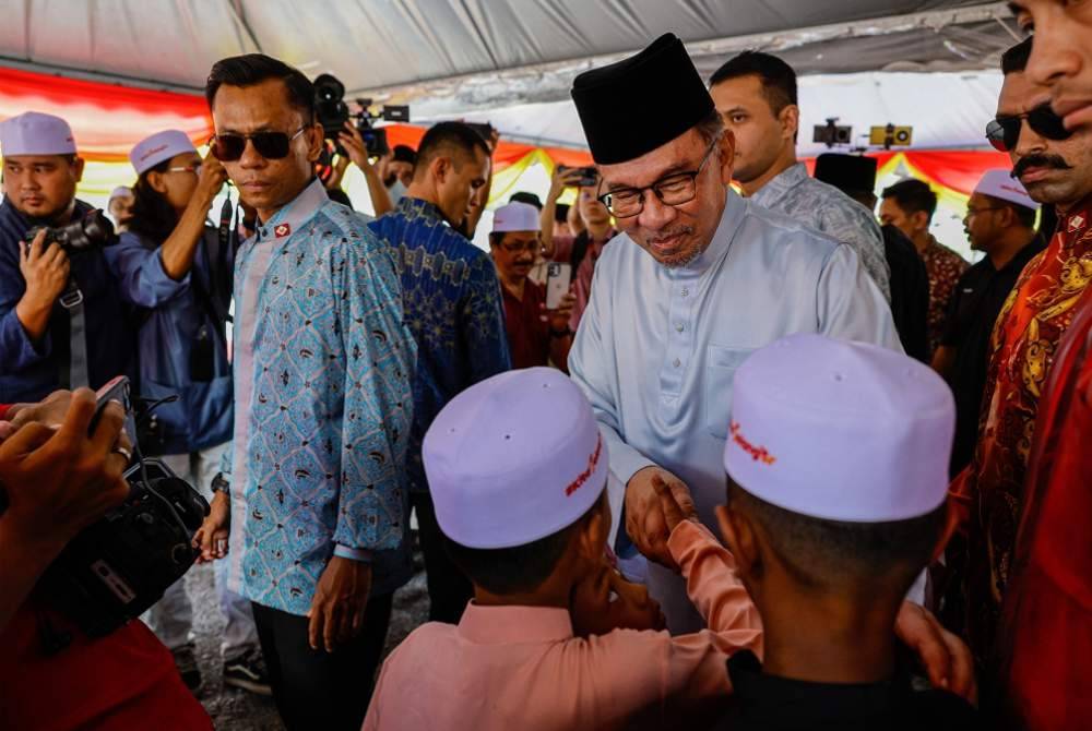Anwar beramah mesra bersama tetamu yang hadir solat Jumaat dan jamuan hari raya di Masjid Bandar Utama Batang Kali pada Jumaat.
