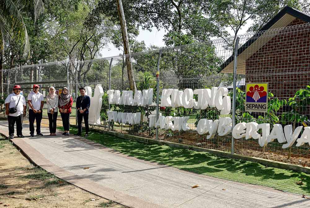 Arefah bergambar bersama petugas di Taman Kucing Cyberjaya. Foto Bernama