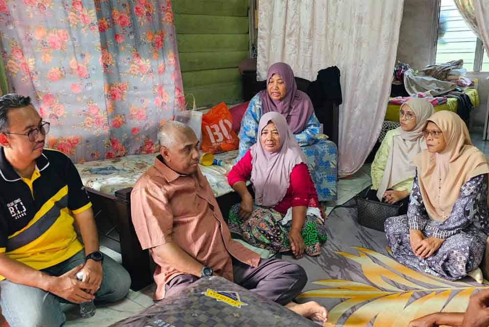 Khairudin (dua dari kanan) melawat keluarga Nor Paezah selepas kediamannya musnah terbakar di Kampung Tua, Parit.