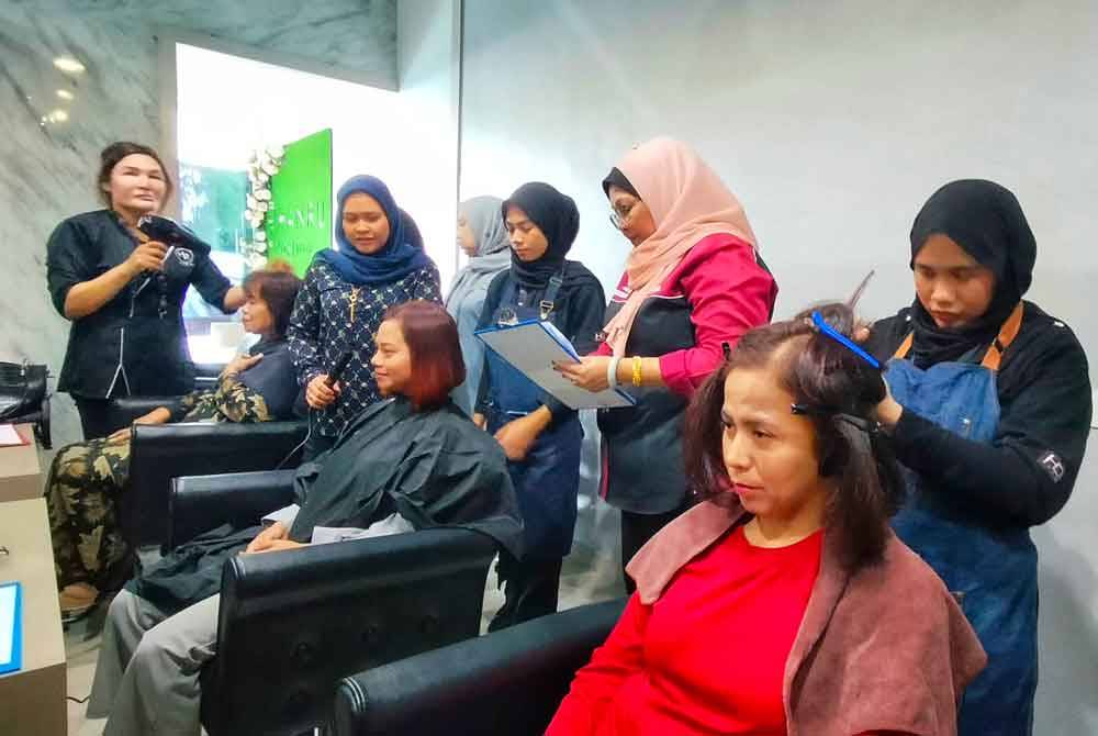 Siti Rohani (berdiri, empat dari kanan) ketika melihat pelajar melakukan peperiksaan amali baru-baru ini.