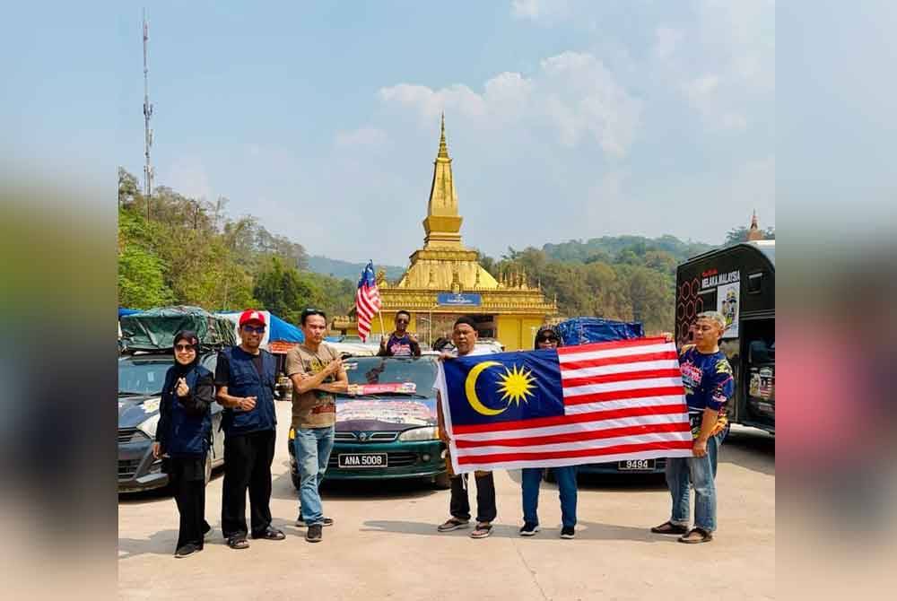 Antara sebahagian peserta Jelajah Malaysia ke Mekah mengibarkan Jalur Gemilang ketika sampai ke sempadan Laos- China.