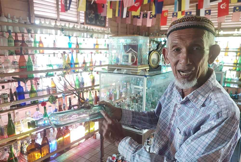Tengku Mohd Ali menunjukkan koleksi botol yang dipamerkan di Rumah Botol Ayahku di Kampung Penarik, Setiu baru-baru ini.