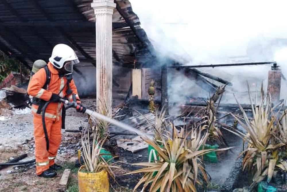 Anggota bomba memadamkan kebakaran di Kampung Damak,Jerantut pada Sabtu. Foto JBPM