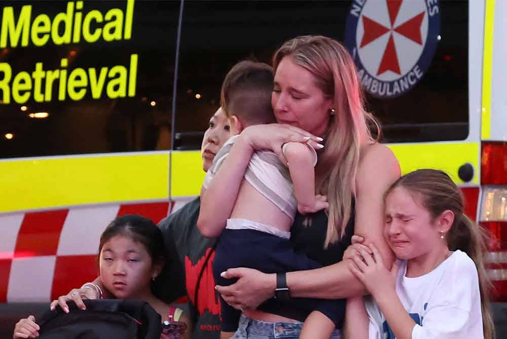 Sebuah keluarga meninggalkan pusat beli-belah Westfield Bondi Junction selepas insiden tikaman pada Sabtu. Foto AFP