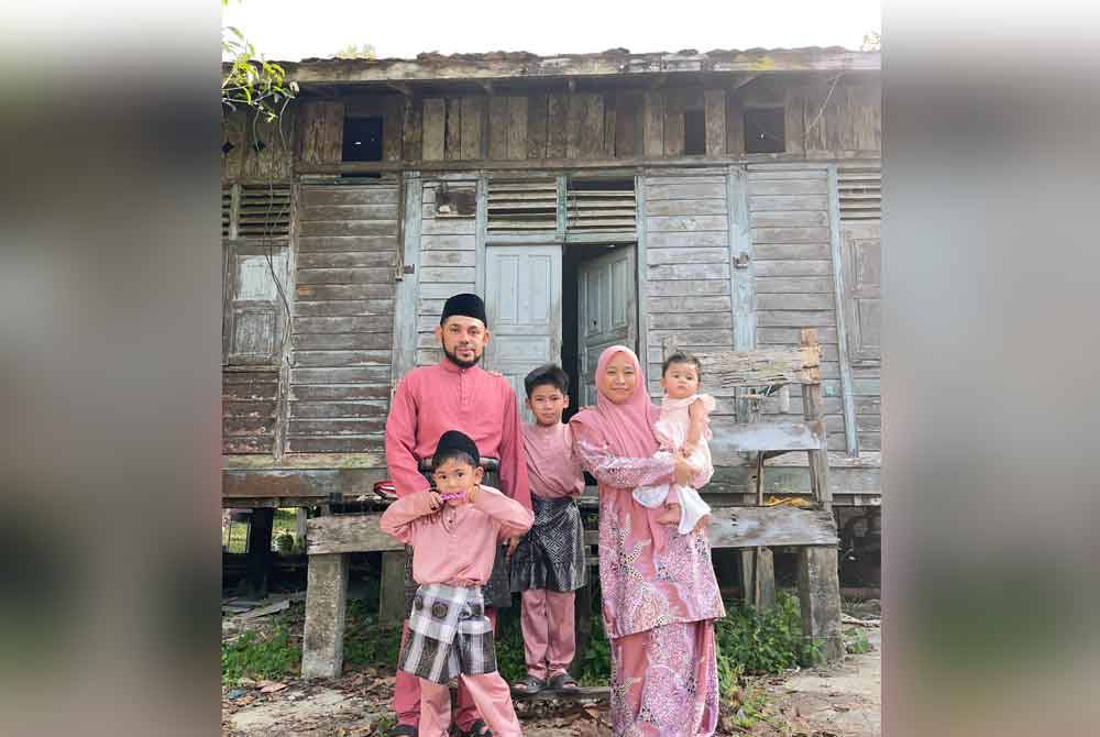Mohd Naizul mengambil gambar bersama keluarga di hadapan rumah usang neneknya di Kampung Jambu Merah, Melor.