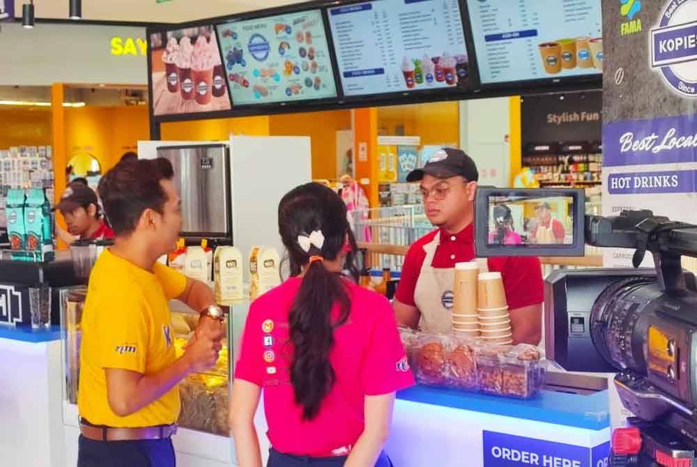 Pelanggan sedang membeli minuman di salah sebuah cawangan Kopiesatu.