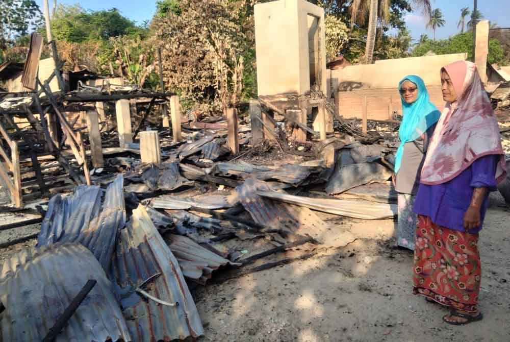 Rosniza (kanan) dan Rosnani melihat kediaman mereka yang musnah dalam kebakaran