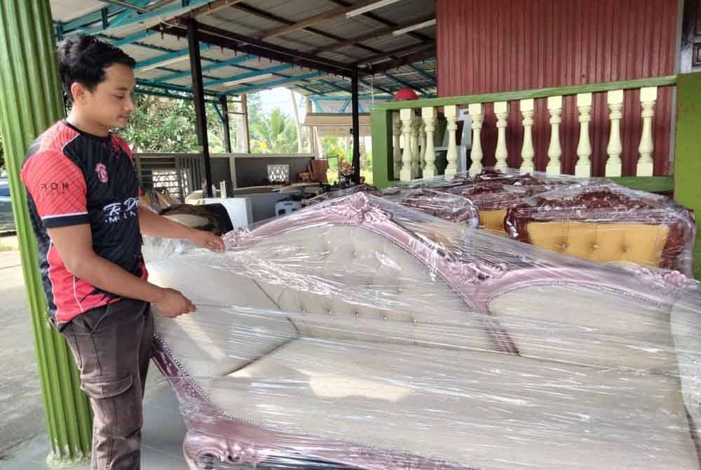 Wan Mohd Zahiruddin menunjukkan sofa yang siap dibaiki dan akan dihantar kepada pelanggan.