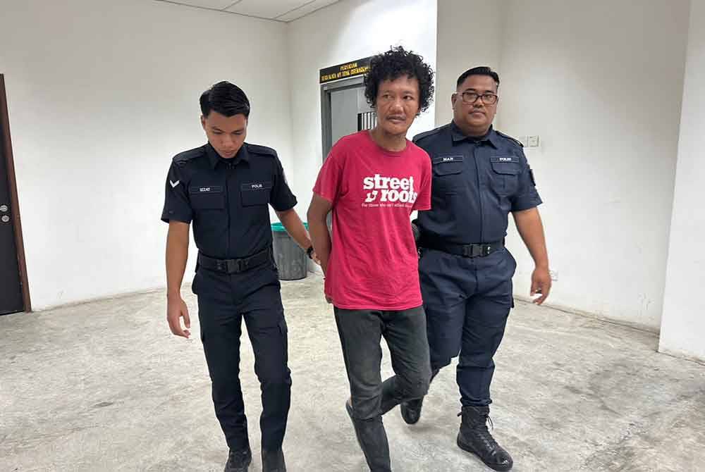 Haslimi (tengah) dikawal polis keluar dari lokap menuju ke bilik mahkamah.