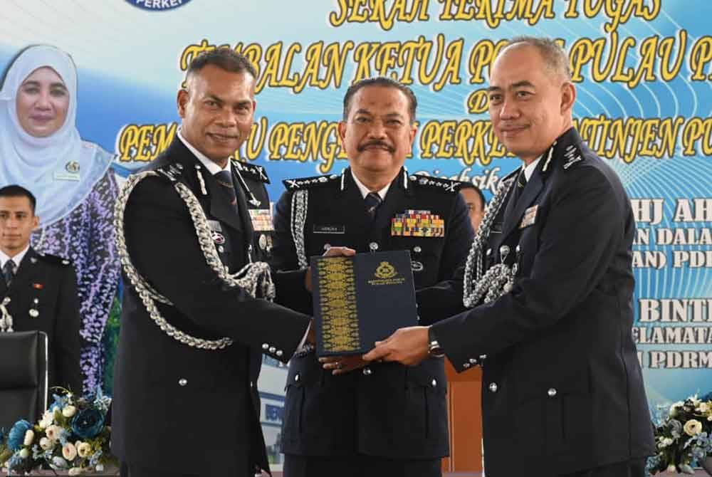 Mohamad Usuf (kiri) menyerahkan dokumen kepada Mohd Alwi sebagai tanda serah terima tugas jawatan Timbalan Ketua Polis Pulau Pinang pada Isnin.