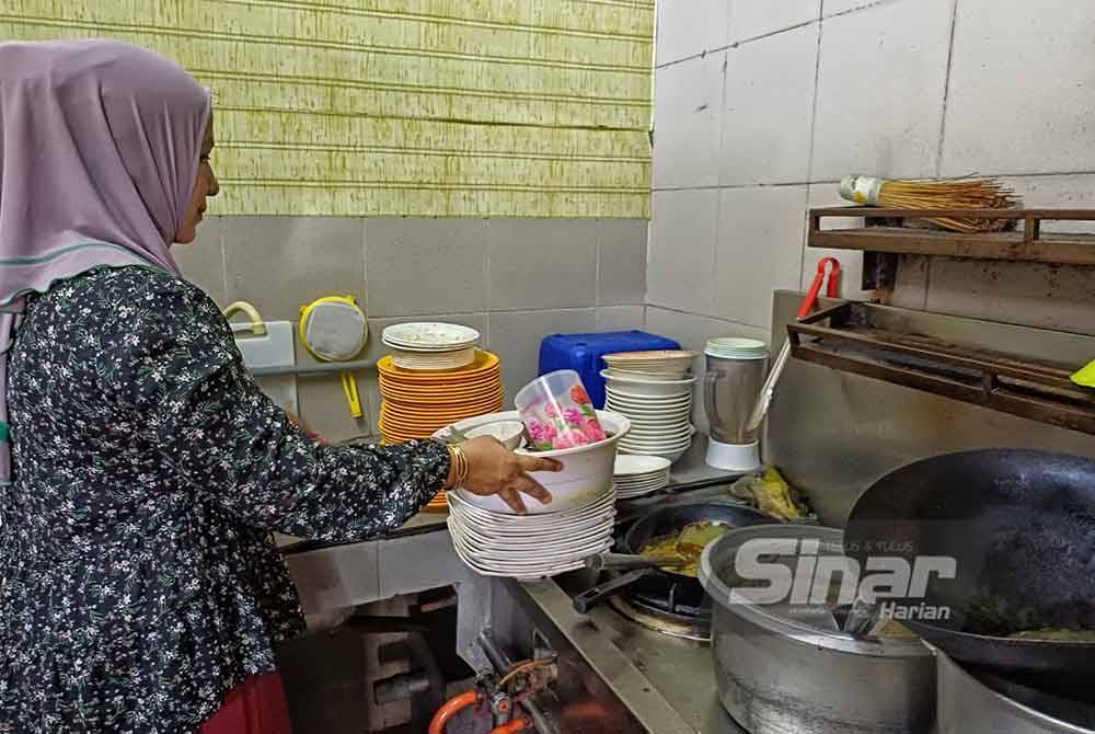 Hanaliza menunjukkan timbunan pinggan mangkuk dan periuk belanga yang tidak dapat dicuci ekoran ketiadaan air di premisnya di medan selera Taman Impianku pada Isnin.