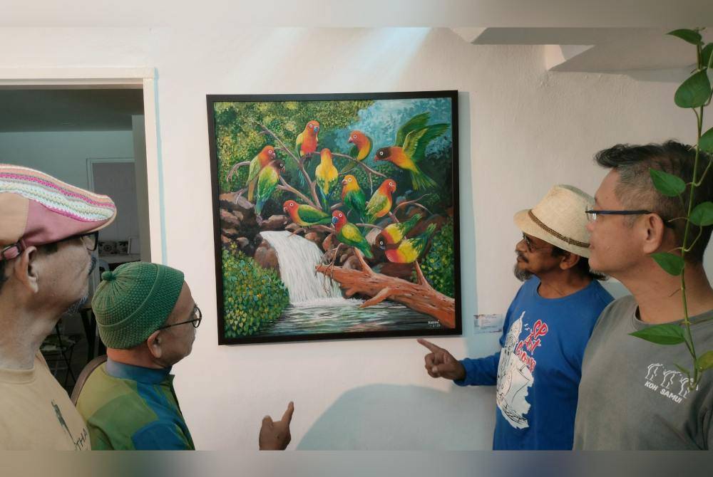 Anuar (dua kanan) dan Eric (kanan) menunjukkan salah satu lukisan yang dipamerkan.