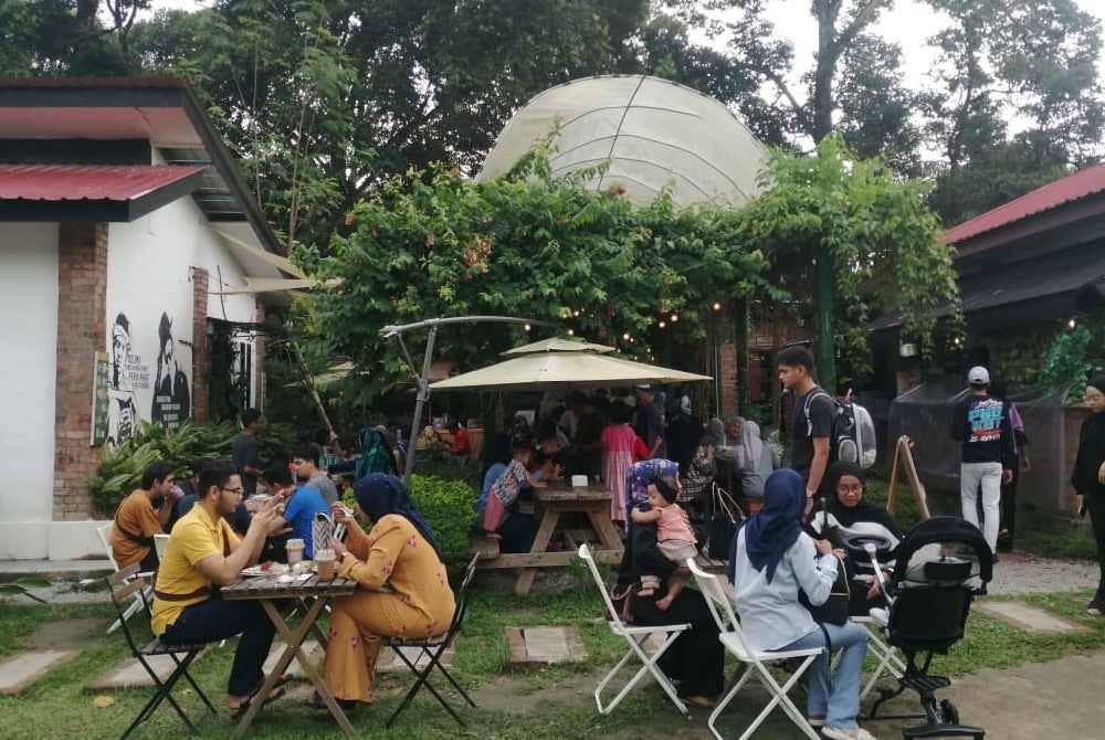 Pengunjung menjamu selera di kafe yang terdapat di Kebun Puisi.