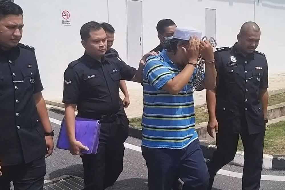 Tertuduh diiringi oleh anggota polis selepas keluar dari Mahkamah Sesyen Kangar pada Selasa.