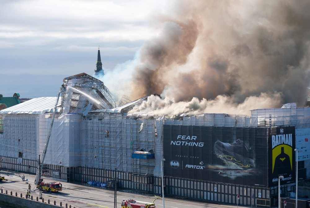 Kepulan asap dari bangunan bersejarah bursa saham Boersen yang terbakar di tengah Copenhagen, Denmark pada Selasa. Bangunan itu didirikan pada tahun 1620-an sebagai bangunan komersial oleh Raja Christian IV dan terletak di sebelah parlimen Denmark. Foto AFP