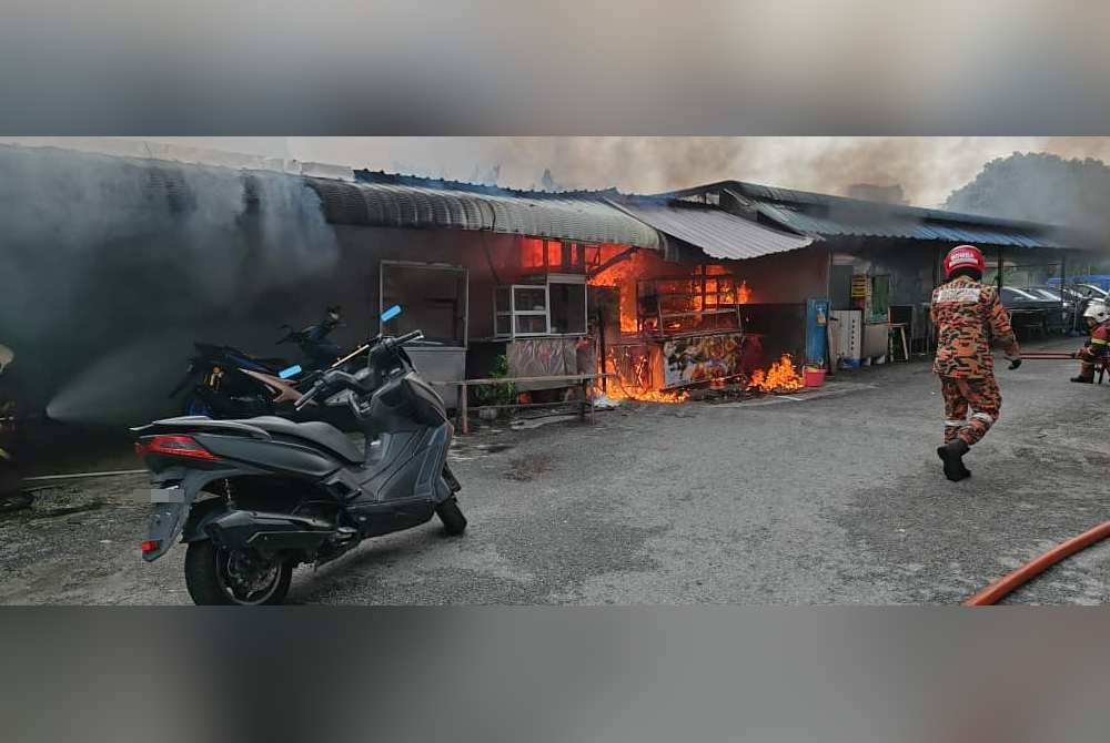 Anggota bomba giat padamkan kebakaran di gerai Nasi Tomato Batu Lanchang pada Selasa.
