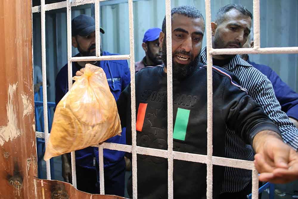 Penduduk Palestin beratur untuk membeli roti bersubsidi di sebuah kedai roti.