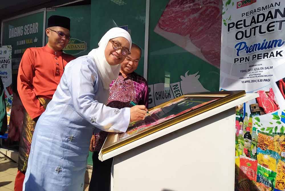 Azulita menandatangani plak perasmian sempena Majlis Perasmian Peladang Outlet Pertubuhan Peladang Negeri Perak di Taman Anda, di sini pada Khamis.