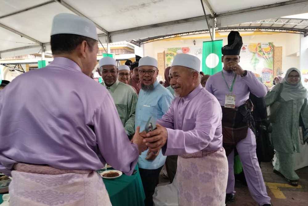 Tuan Ibrahim bersalaman dengan tetamu yang menghadiri Rumah Terbuka Aidilfitri Pas Kelantan di Dataran Warisan Stadium Muhammad IV.