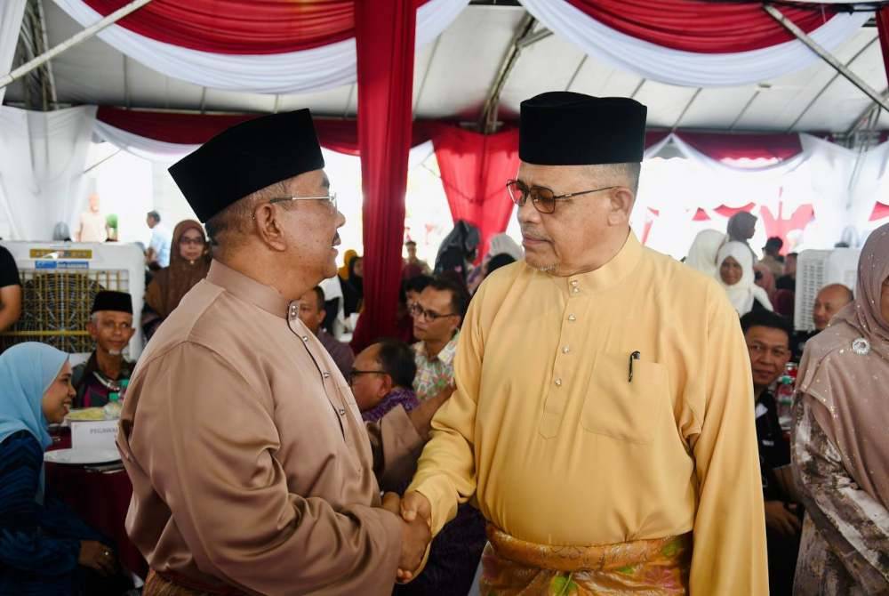 Sanusi (kiri) bersalaman dengan Ahli Parlimen Arau, Datuk Seri Shahidan Kassim yang hadir pada majlis Rumah Terbuka di Seri Mentaloon.