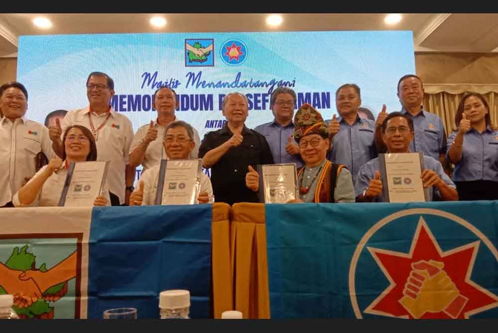 Pairin (berdiri tengah) menyaksikan majlis menandatangani MoU antara PBS dan STAR di Dewan Hongkod Koisaan, Penampang.