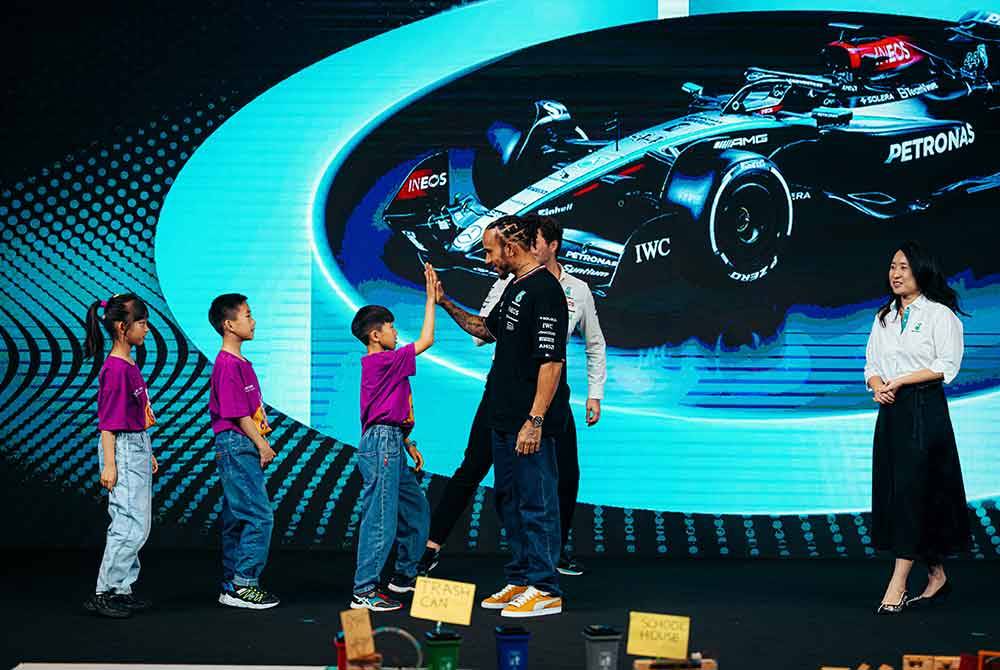 Hamilton bersama salah satu pasukan pemenang Pertandingan Pidato Bahasa Inggeris Voice Student semasa sesi bertemu dan sapa khas di Shanghai, China.